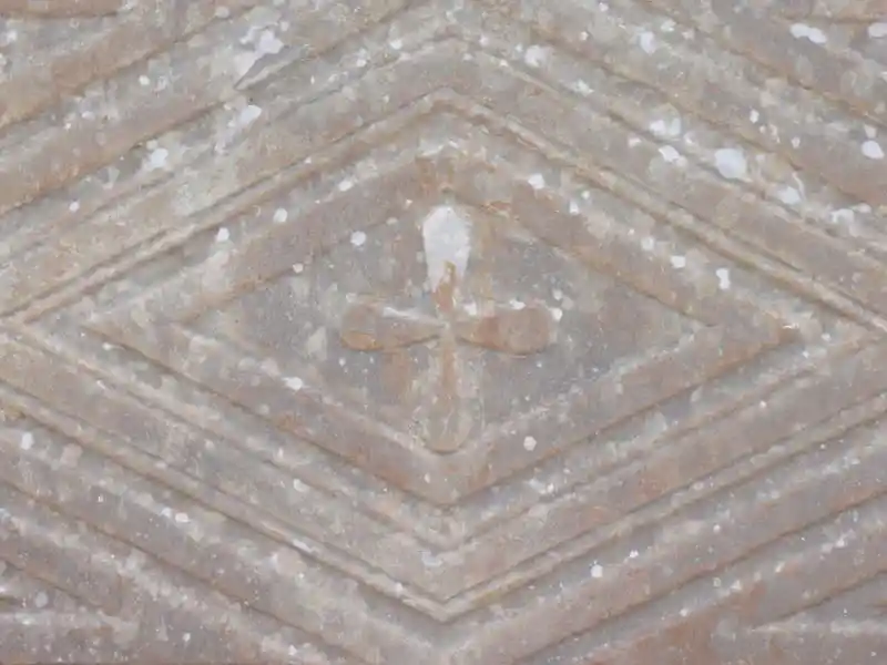 Diamond with a cross inside engraved on a marble stone